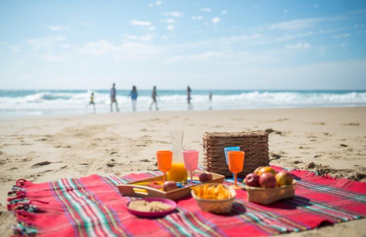 Una tovaglia con del cibo in spiaggia